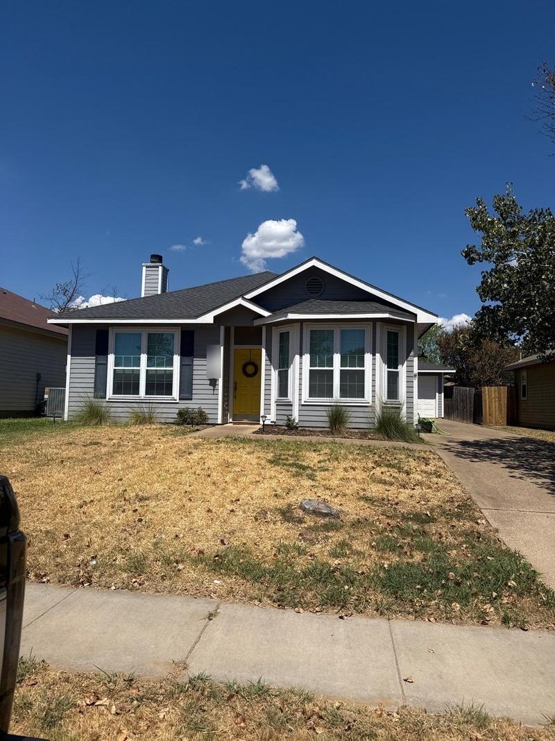 One-story home with its original gray lap siding and white trim before replacement