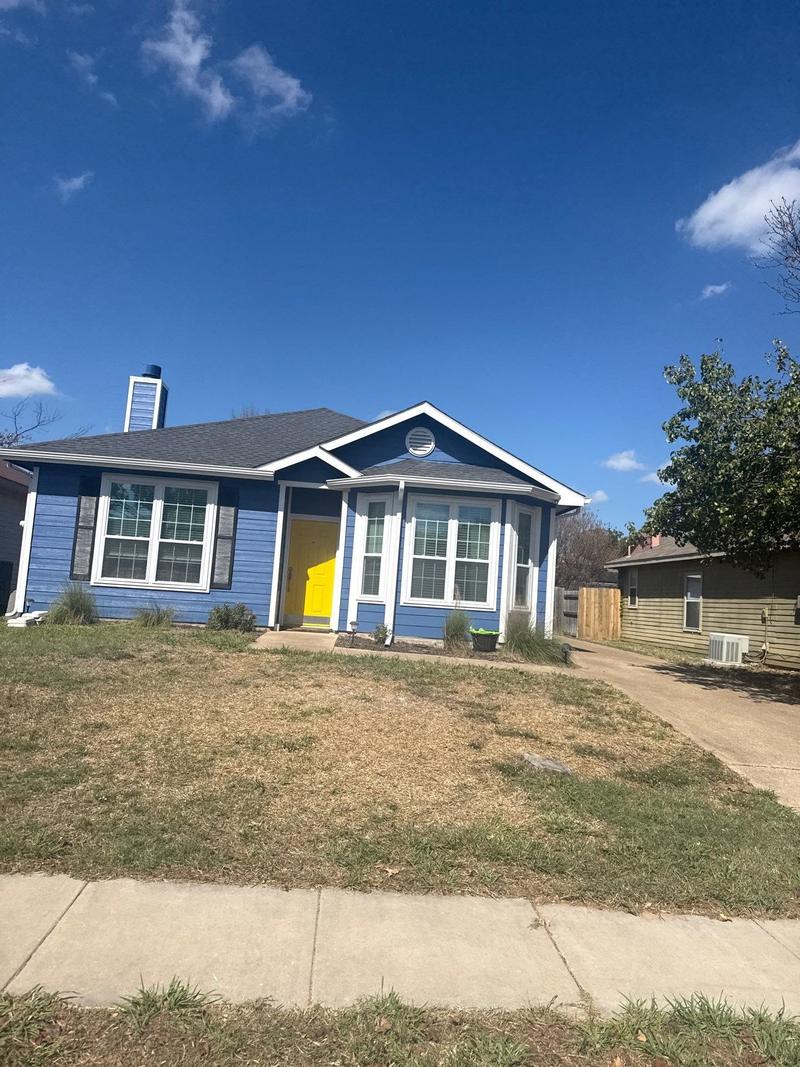 The same one-story home after new lap siding, painted blue with white trim and a yellow front door