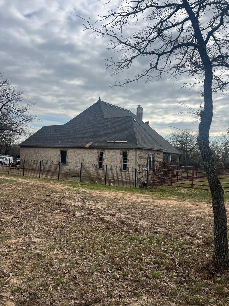 Stone home with a slate-look shingle roof on acreage in Wise County