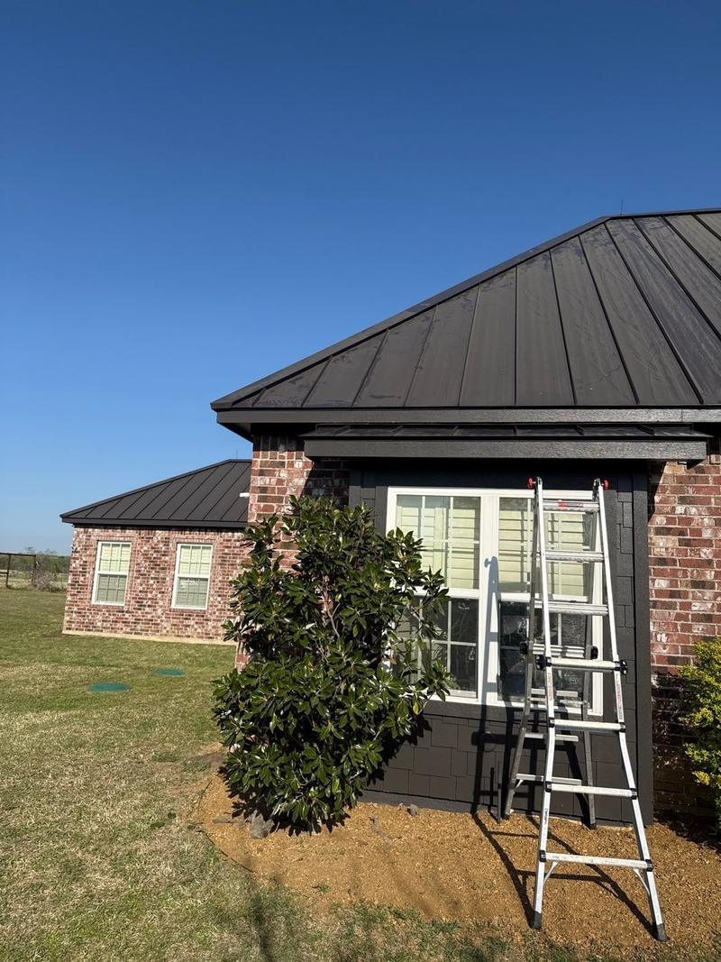 Dark bronze standing seam metal roof replacing shingles on a red brick ranch home near Sanger, TX